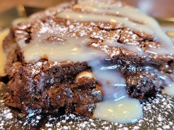 Dark chocolate fudgy brownie with vanilla ice cream and white chocolate sauce