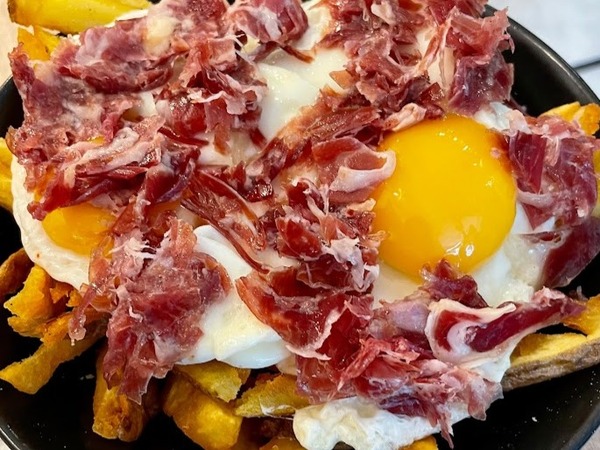 Fried eggs with fries and iberian ham