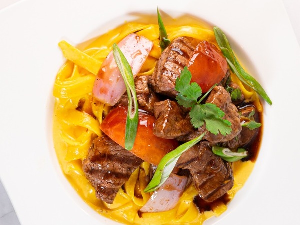 Lomo saltado con fettuccine huancaína
