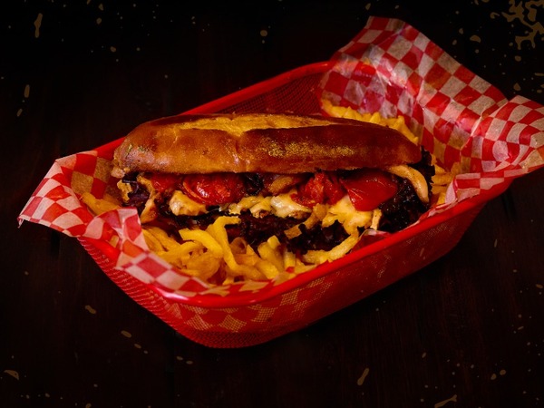 Flaco Traverso: Colita de cuadril, cebolla morada caramelizada, queso grillado, tomate asado, col blanca y salsa Spicy.