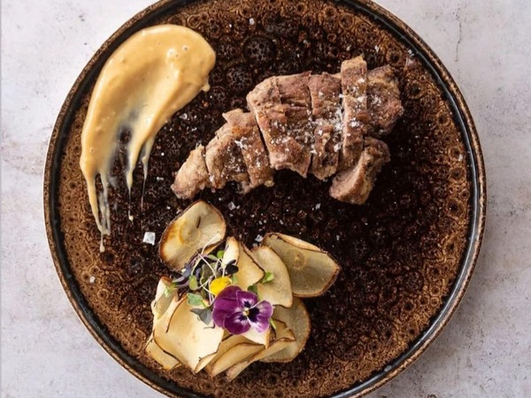 Pluma ibérica a la brasa con crema de turrón y chips de yuca