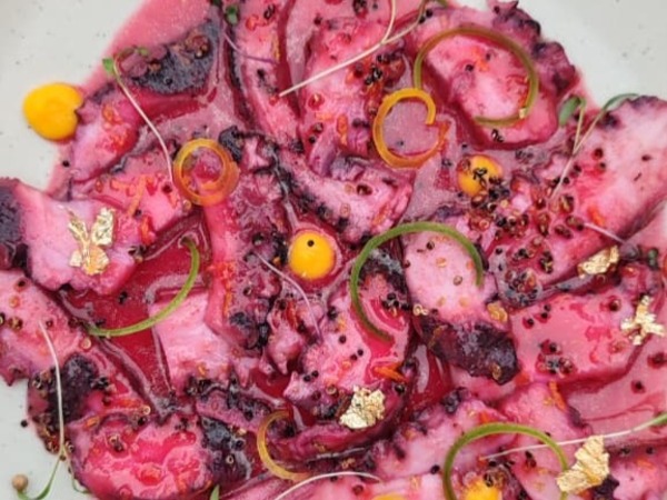 Glazed octopus with orange and beetroot served with crispy quinoa.