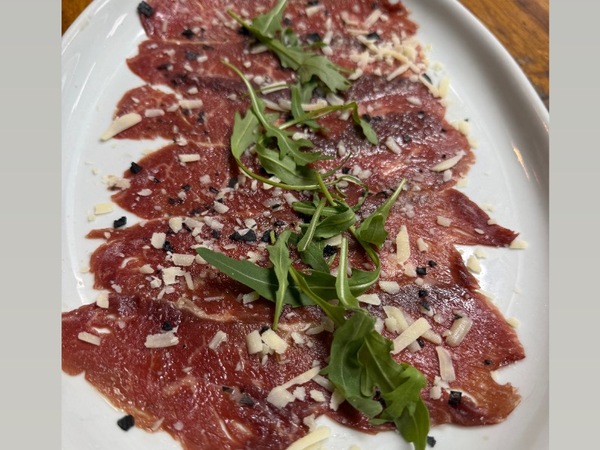 Carpaccio de vacuno mayor aderezado con AOVE ,aceite de trufa,parmesano y rucula